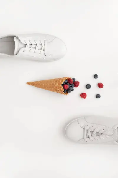 Weiße Damensneakers Und Ein Horn Mit Sommerbeeren Auf Hellem Hintergrund — Stockfoto