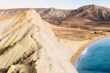 Uçurumun ridge riskli dar yolda. Karadeniz kıyı şeridi, gizli plaj, sarı ve kahverengi hills güneşli bir günde görüntüleyin. Cape bukalemun, Koktebel, Crimea