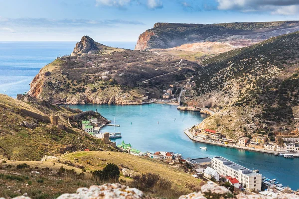 Güneşli bahar günü kar maskesi koyda yukarıdan. Karadeniz limanı ile güzel tepeler ve binalar eski şehrin görünümünü. Sevastopol, Crimea