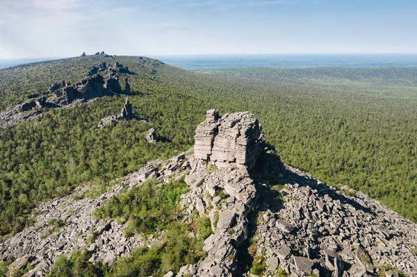 Krasnovishersk yakınlarındaki yeşil taiga ormanı arasında antik Pomyanenny (Kolchimsky) taş kalıntıpanoramik havadan görünümü, Perm krai, Rusya. Ural dağlarında popüler yürüyüş yeri