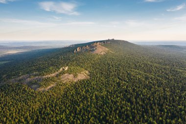 Bir yaz akşamı taiga ormanı arasında Pomyanenny (Kolchimsky) taş ile Ural dağları sırt Panoramik havadan görünümü. Krasnovishersk yakınlarındaki popüler turistik yer, Perm krai, Rusya.