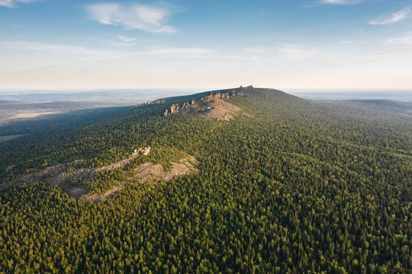 Bir yaz akşamı taiga ormanı arasında Pomyanenny (Kolchimsky) taş ile Ural dağları sırt Panoramik havadan görünümü. Krasnovishersk yakınlarındaki popüler turistik yer, Perm krai, Rusya.