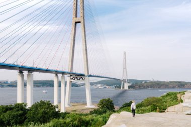 Gezgin, Vladivostok Şehri 'ni Doğu Boğazı' nın üzerindeki Russky Adası 'na bağlayan Russky Köprüsü' ne bakıyor. Primorsky Krai, Uzak Doğu, Rusya 'da deniz üzerinde kablo destekli yol köprüsü