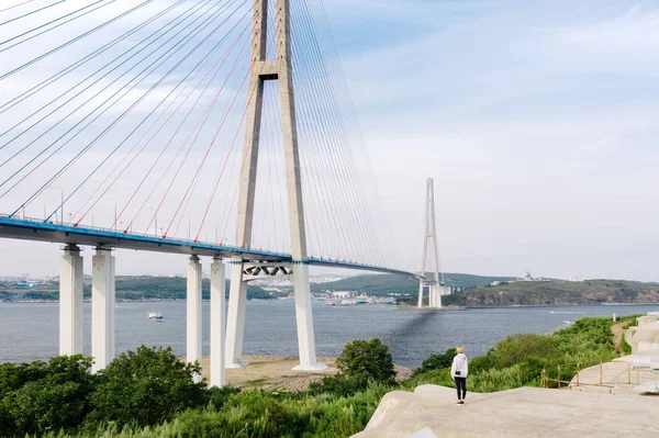 Gezgin, Vladivostok Şehri 'ni Doğu Boğazı' nın üzerindeki Russky Adası 'na bağlayan Russky Köprüsü' ne bakıyor. Primorsky Krai, Uzak Doğu, Rusya 'da deniz üzerinde kablo destekli yol köprüsü