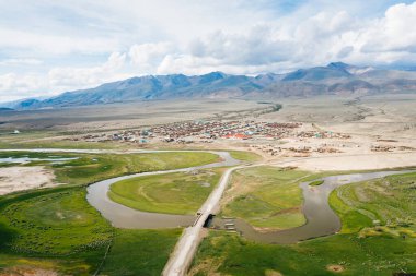 Chuya Nehri ve Altai Dağları 'nın Chuya Steppe vadisindeki Ortolyk köyü panoramik hava manzaralı. Altai Cumhuriyeti, Sibirya, Rusya 'da yeşil çayır ve kuru arazi manzarası