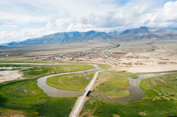 Chuya Nehri ve Altai Dağları 'nın Chuya Steppe vadisindeki Ortolyk köyü panoramik hava manzaralı. Altai Cumhuriyeti, Sibirya, Rusya 'da yeşil çayır ve kuru arazi manzarası