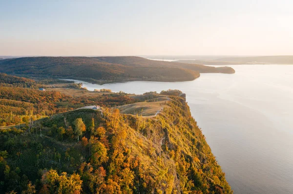 Zhiguli Dağları 'ndan Molodetsky Barrow gün batımında Volga Nehri kıyısında, panoramik hava manzaralı. Samarskaya Luka Ulusal Parkı 'ndaki turuncu yapraklı sonbahar manzarası. Samara Oblağı, Rusya