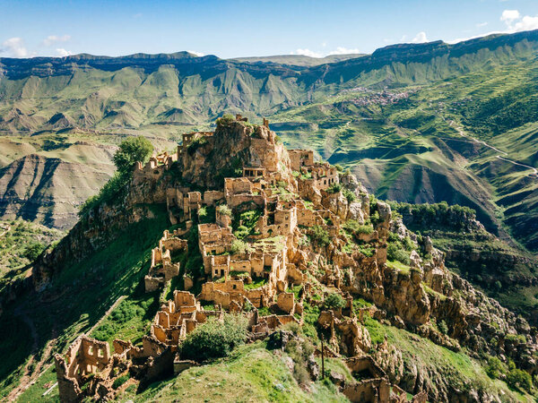 Деревня Гамсутль в горах Кавказа. Старые каменные здания на вершине скалы. Летнее утро в Дагестане, Россия