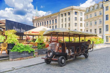 Riga, Letonya 16 Haziran 2017: Cep bira bar old Riga Caddesi üzerinde. Orijinal Nakliyat a.ş.-bisiklet sürücüsü olan bir araba.
