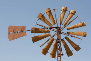 Blu gökyüzü güneş ışığı büyük eski rounde Yunan paslı demir yel değirmeni