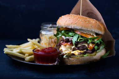 burger patates kızartması ve Barbekü sos siyah plaka üzerinde Close-up