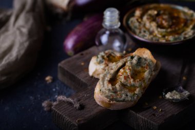 tahin, zeytinyağı ve limon suyu siyah arka plan üzerine püresi patlıcan snack