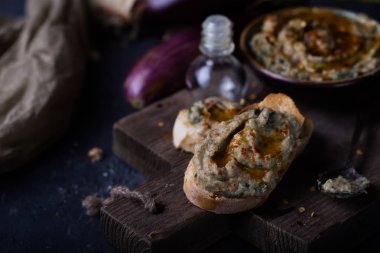 snack of mashed eggplants with sesame paste, olive oil and lemon juice on black background clipart