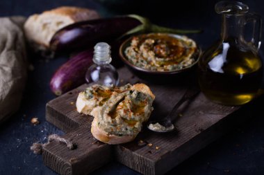tahin, zeytinyağı ve limon suyu siyah arka plan üzerine püresi patlıcan snack
