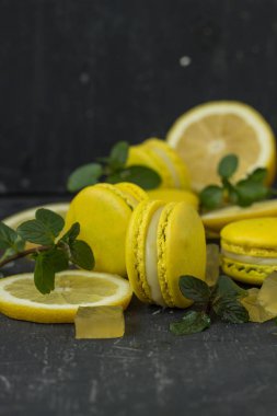 siyah arka plan üzerine limon macarons ile nane yaprakları