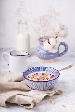 çilek ve mavi kapta süt ile granola