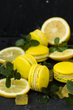 siyah arka plan üzerine limon macarons ile nane yaprakları