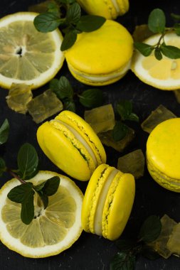 siyah arka plan üzerine limon macarons ile nane yaprakları