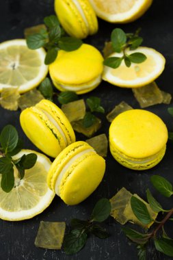 siyah arka plan üzerine limon macarons ile nane yaprakları