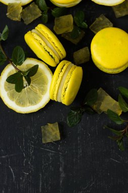 siyah arka plan üzerine limon macarons ile nane yaprakları