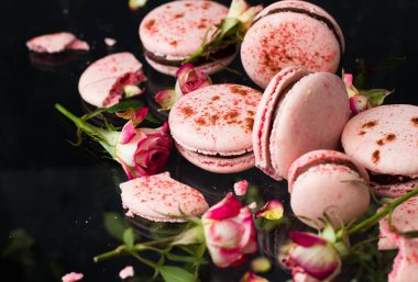 siyah arka plan, seçici odak üzerine gül çiçekli pembe macarons 
