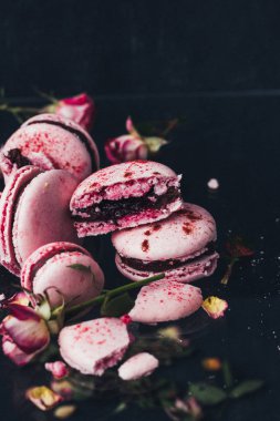 siyah arka plan, seçici odak üzerine gül çiçekli pembe macarons 