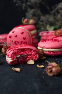 siyah arka plan, seçici odak üzerine gül çiçekli pembe macarons 