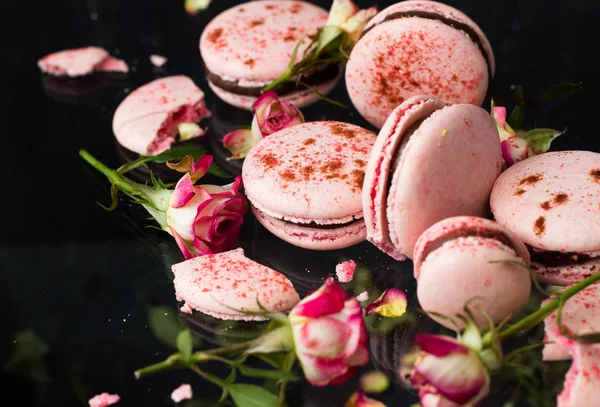 Siyah Arka Plan Seçici Odak Üzerine Gül Çiçekli Pembe Macarons — Stok fotoğraf