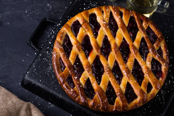 pie with wild blackberries on wooden background