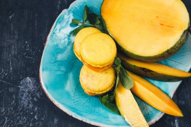 mango siyah arka plan, seçici odak ile sarı macarons 