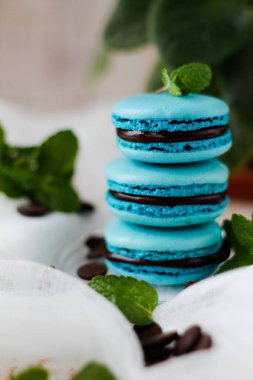 macarons kahve ve nane yaprakları ile mavi, ön plan üzerinde odaklanmak