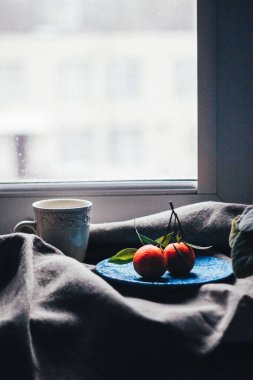 Mavi plaka, seçici odak üzerinde yeşil yaprakları ile taze mandalina