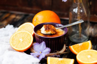 Turuncu krem brulee kase ahşap arka plan, seçici odak üzerinde