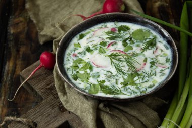 Bahar çorbası ahşap arka plan üzerinde turp ve yeşil soğan ile