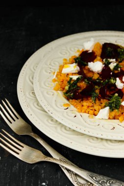 Mercimek ve siyah arka plan üzerine beyaz plaka pancar salatası 