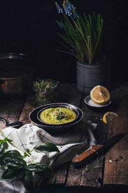 Yeşil bezelye ve ahşap arka plan, seçici odak içinde siyah kase ıspanak çorbası