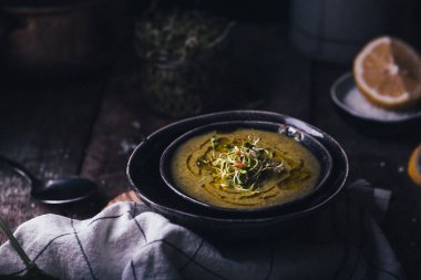 Yeşil bezelye ve ahşap arka plan, seçici odak içinde siyah kase ıspanak çorbası