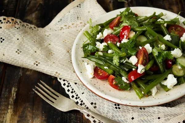 salad of green beans with tomatoes, cucumbers, cheese and greens