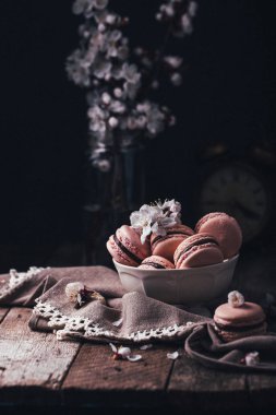 ahşap arka plan üzerinde beyaz çiçekler ile çikolata macaroons 
