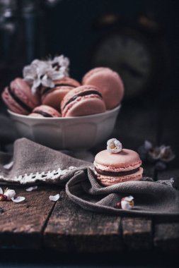 ahşap arka plan üzerinde beyaz çiçekler ile çikolata macaroons 