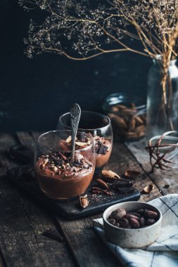 Ahşap zemin üzerine kaşık ile cam çikolata mousse
