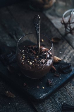 Ahşap zemin üzerine kaşık ile cam çikolata mousse