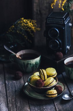 ahşap masa üzerinde kahve ve makaron ile fincan