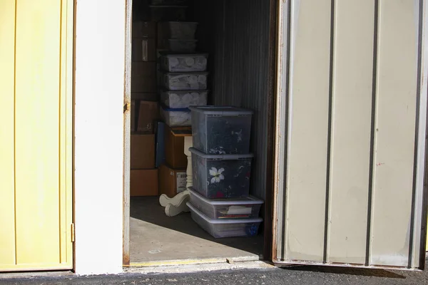 Close up of a storage unit with furniture and boxes in a secure self storage facility with multiple drive up units.