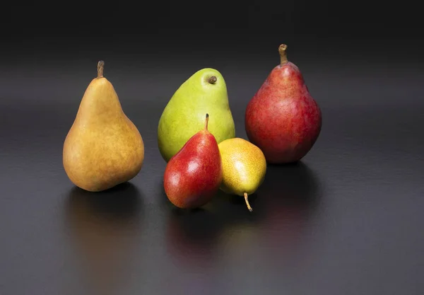 Healthy and nutritious snacks.  Delicious fresh pears on a black background.  Forelle, Bosc, D'Anjou, Starkrimson Red Pears variety.