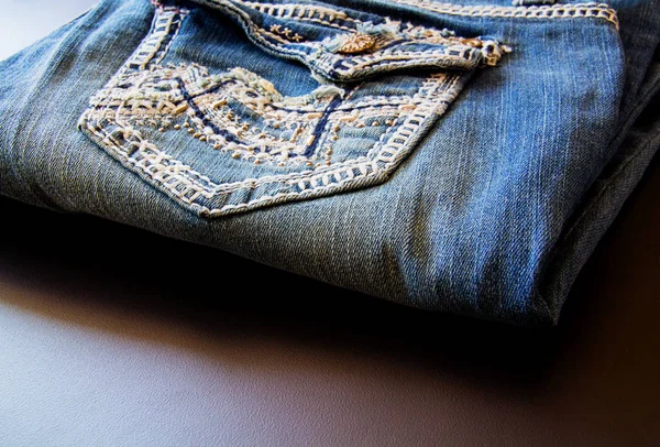 Close up of retro look denim jeans small front pocket with hand embellished embroidery stitching detail.