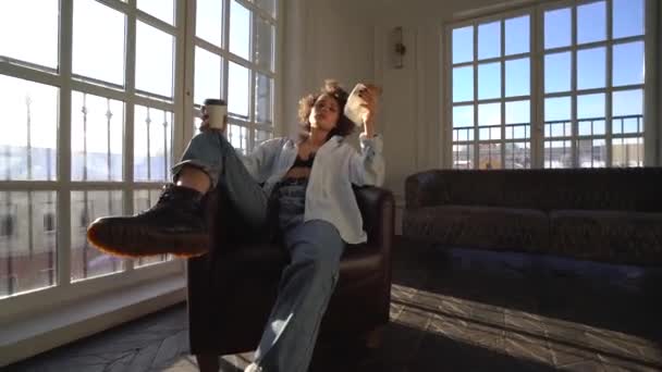 Dziewczyna Ciemne Kręcone Włosy Siedzi Krześle Brązowy Ręku Trzyma Kawę — Wideo stockowe