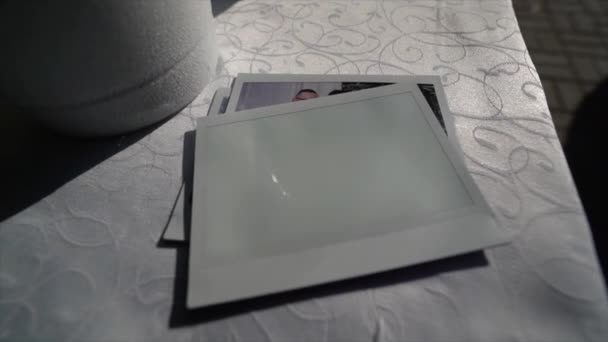 Auf Dem Weißen Tisch Liegt Ein Leeres Polaroid Foto — Stockvideo