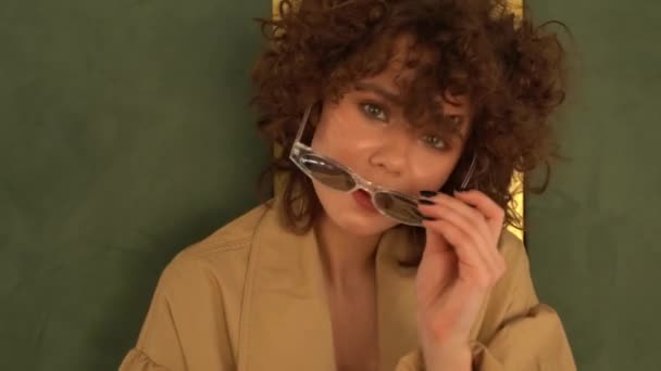 水着とマントの壁 ポージングの巻き毛を持つ女性 クローズ アップ ファッション撮影 — ストック動画