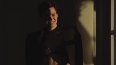 Kısa saç kesimi güzel bir kadınla siyah iç çamaşırı giymiş ve siyah bir adamın ceketi durgunluk gölge ve gülüyor